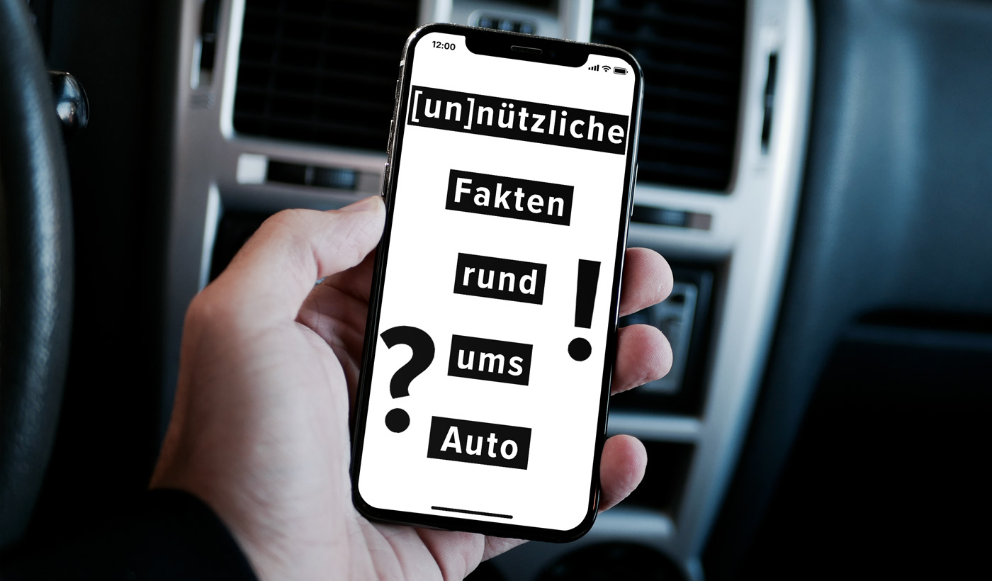 Mann hält Handy in einem Auto