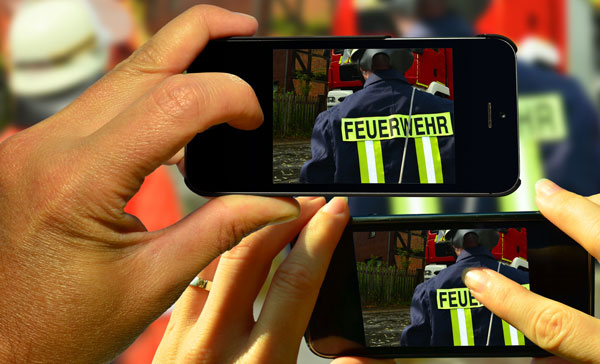 Gaffer welche Feuerwehrmänner im Einsatz fotografieren.