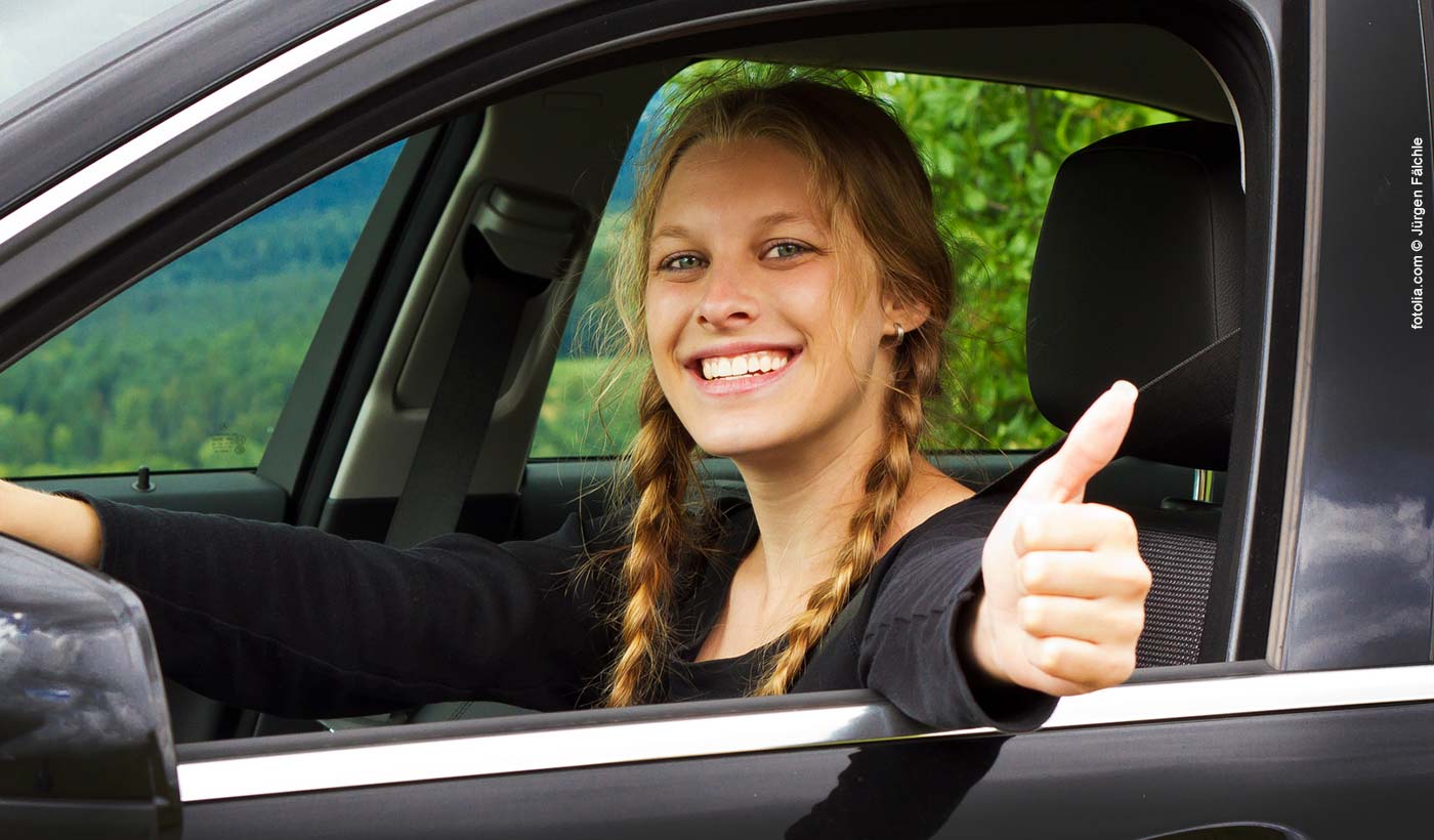 Frau im Auto mit Daumen Hoch