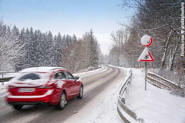 Auto auf verschneiter Fahrbahn
