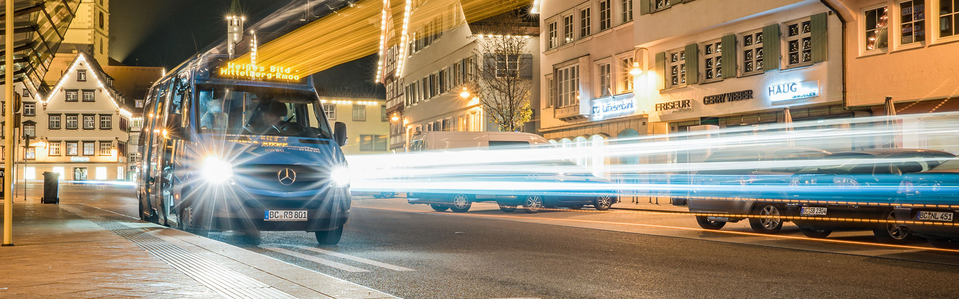 Tankkarten können kleinen Unternehmen helfen, Tank-, Lade- und weitere Mobilitätskosten zentral und übersichtlich zu verwalten. Transporter fährt nachts durch eine beleuchtete Innenstadt