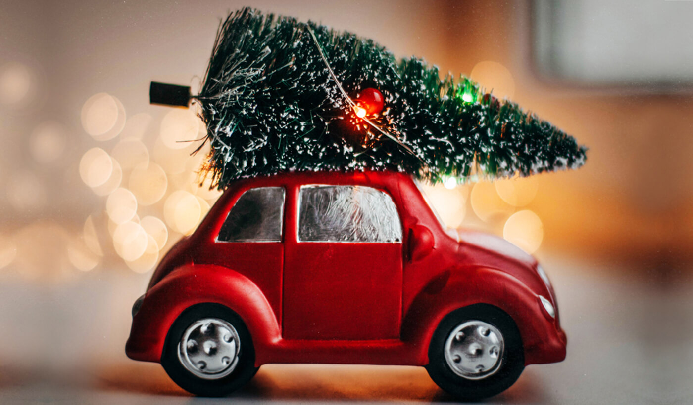 Auto mit Weihnachtsbaum auf dem Dach