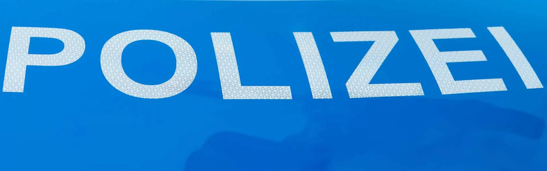 Ab 28.04.2020 treten die neuen Regelungen der Straßenverkehrsordnung in Kraft Arm der eine "HALT POLIZEI" Kelle hält mit Polizeischriftzug im Hintergrund